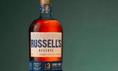 Bottle of Russell’s Reserve 13-Year-Old bourbon against green backdrop