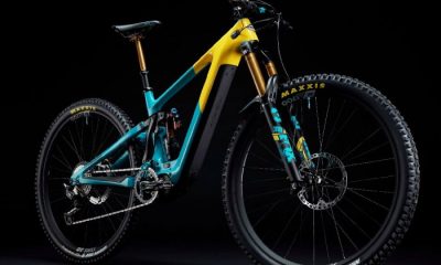 Bright blue and yellow electric mountain bike against black backdrop