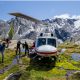 Hikers disembark from a helicopter parked in the Western Canadian mountains