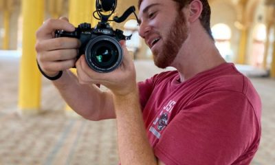 Drew Binsky in a red shirt holding a camera