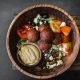 Bowl with greens, falafel, tomato. and tahini