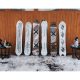 Six black and white patterned snowboards leaning against wall