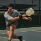 Man lunging on court with racket in hand