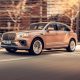Rose colored 2023 Bentley Bentayga Extended Wheelbase, front side, driving on the road