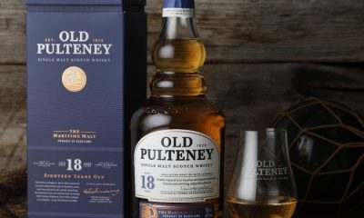 Bottle of Old Pulteney 18-Year-Old whisky next to a filled glass and packaging