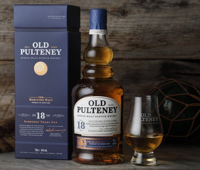Bottle of Old Pulteney 18-Year-Old whisky next to a filled glass and packaging