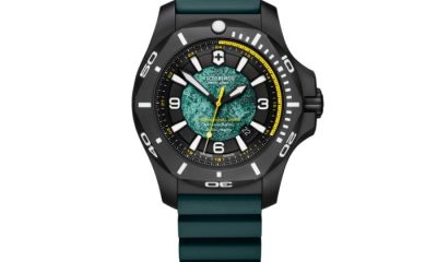 Green and black Victorinox I.N.OX. watch on a white background.