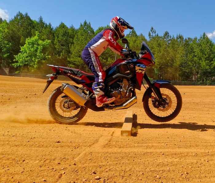 Riding motorcycle on dirt over obstacle