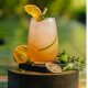 The California Sunset cocktail on an outdoor surface with garnish