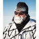 Older caucasian man wearin black banie and sunglasses with white and black fleece and beard covered in ice