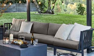 Grey outdoor furniture with wine bottles and glasses on concrete table