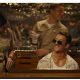 Miles Teller in shades sits at the piano during a scene from Top Gun: Maverick