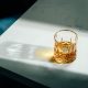 Glass of whiskey in sunlight on white tabletop