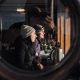 Two women looking out window through porthole