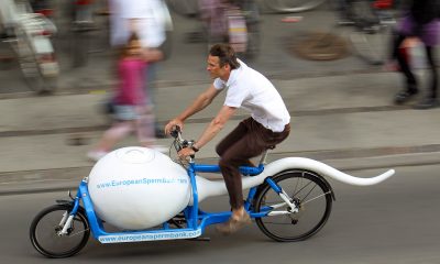courier on a sperm shaped bicycle speeding down the road