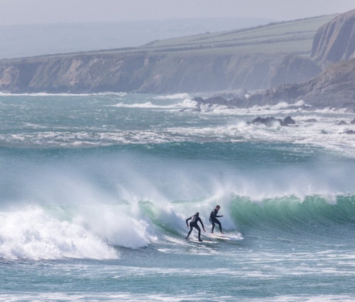 Two surfers on a wave on Ireland's west coast.