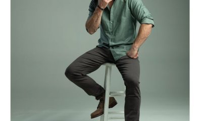 Actor Chris Hemsworth posing in green button-down on stool