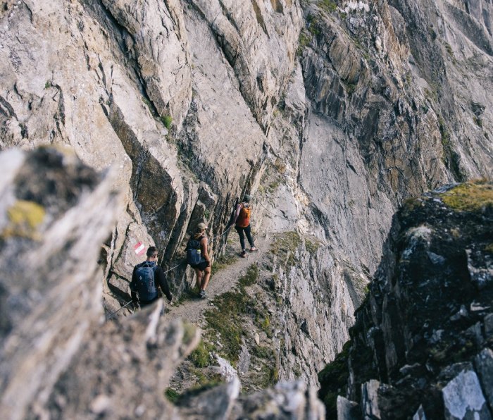Hikers walking along via ferrata cliff on Austria's Eagle Way