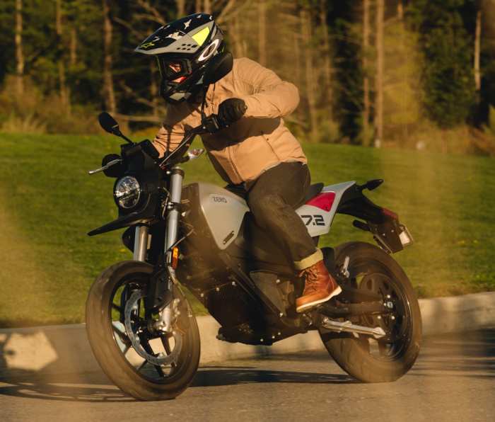Man riding a Zero FXE motorcycle on a road.