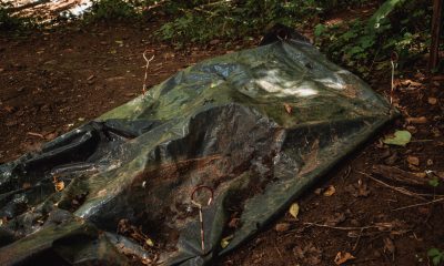 A donor body under a tarp at the decomp facility