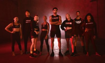 Group of male and female fitness instructors standing in red-hued light