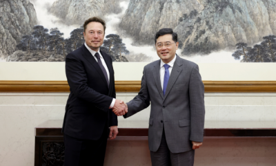 Musk holding hands with Qin Gang, China's Minister of Foreign Affairs